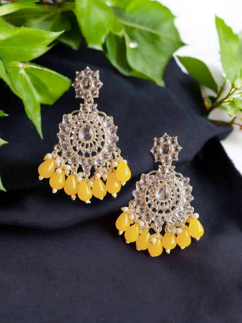 Introducing kundan and polki stone earrings. Feature kundan and polki stones with diamond crystals. Adorned with yellow color beads hanging down that adds a movement to earrings.